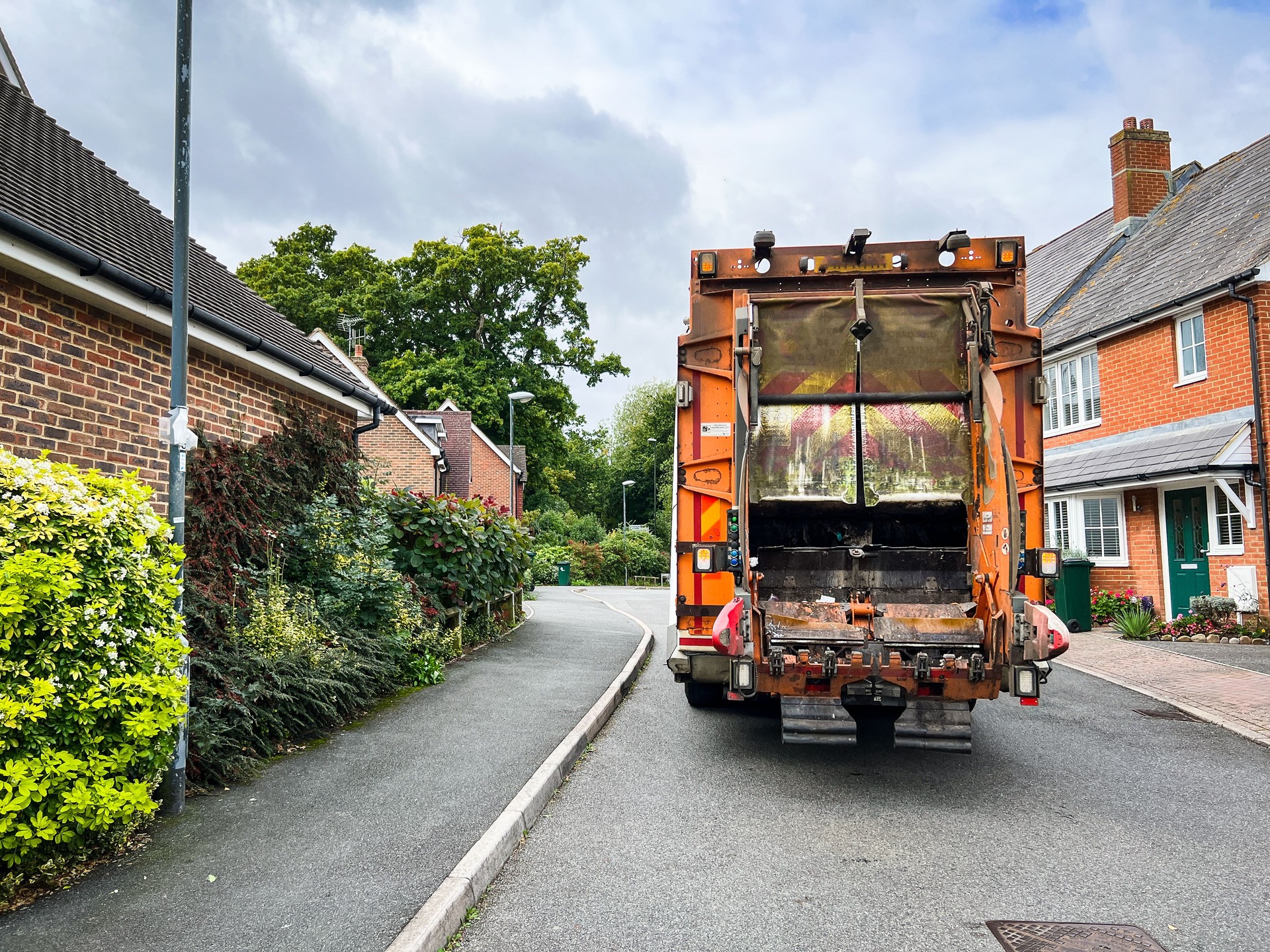 Garbage truck doing rubbish collection on residential street